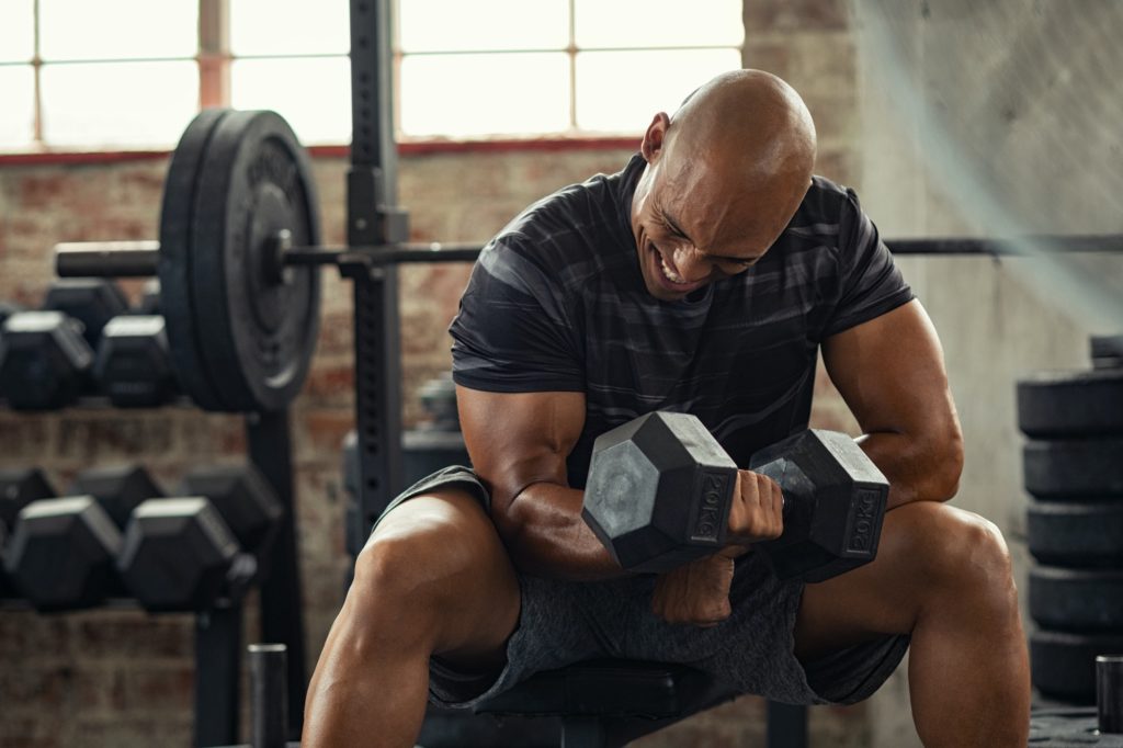 Strong man lifting weight at gym
